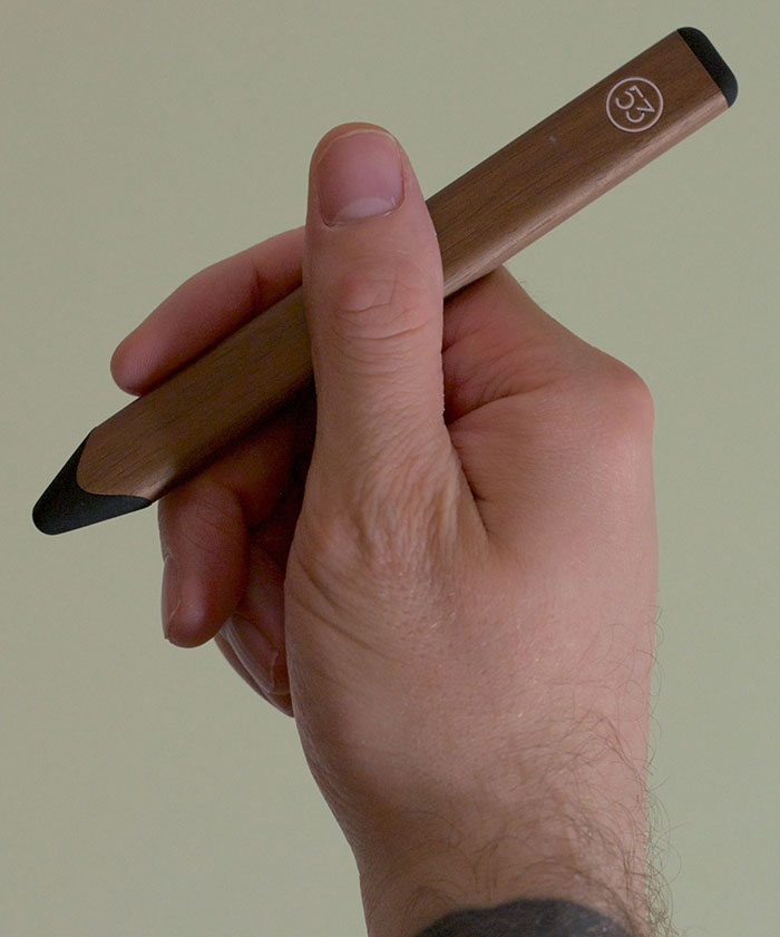 Hand holding Pencil stylus with a traditional writing grip.